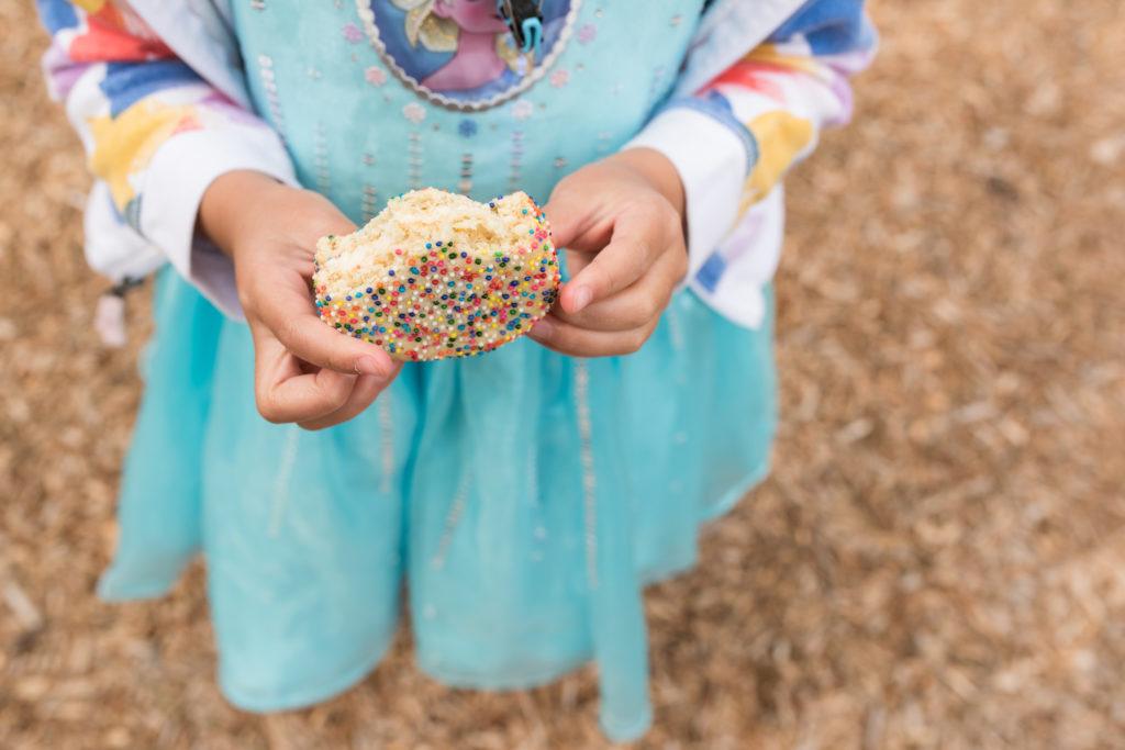 Manos de niño que desmenuzan la golosina del postre