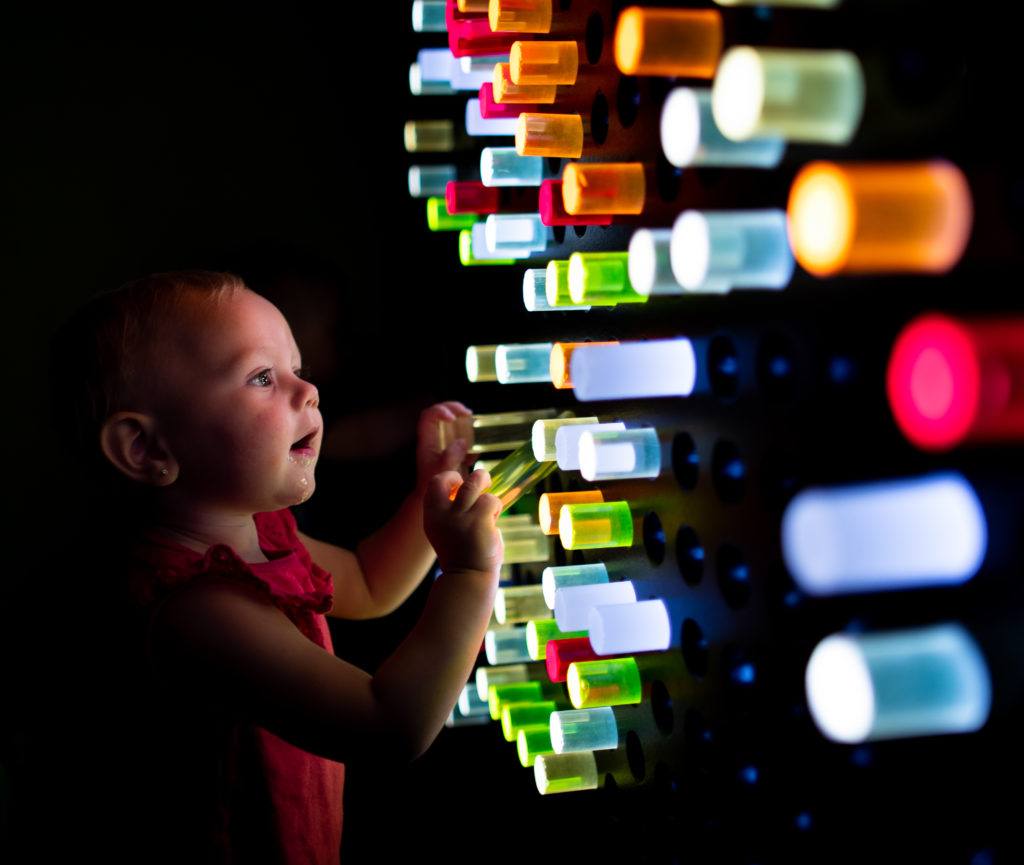 niño jugando con la pared iluminada