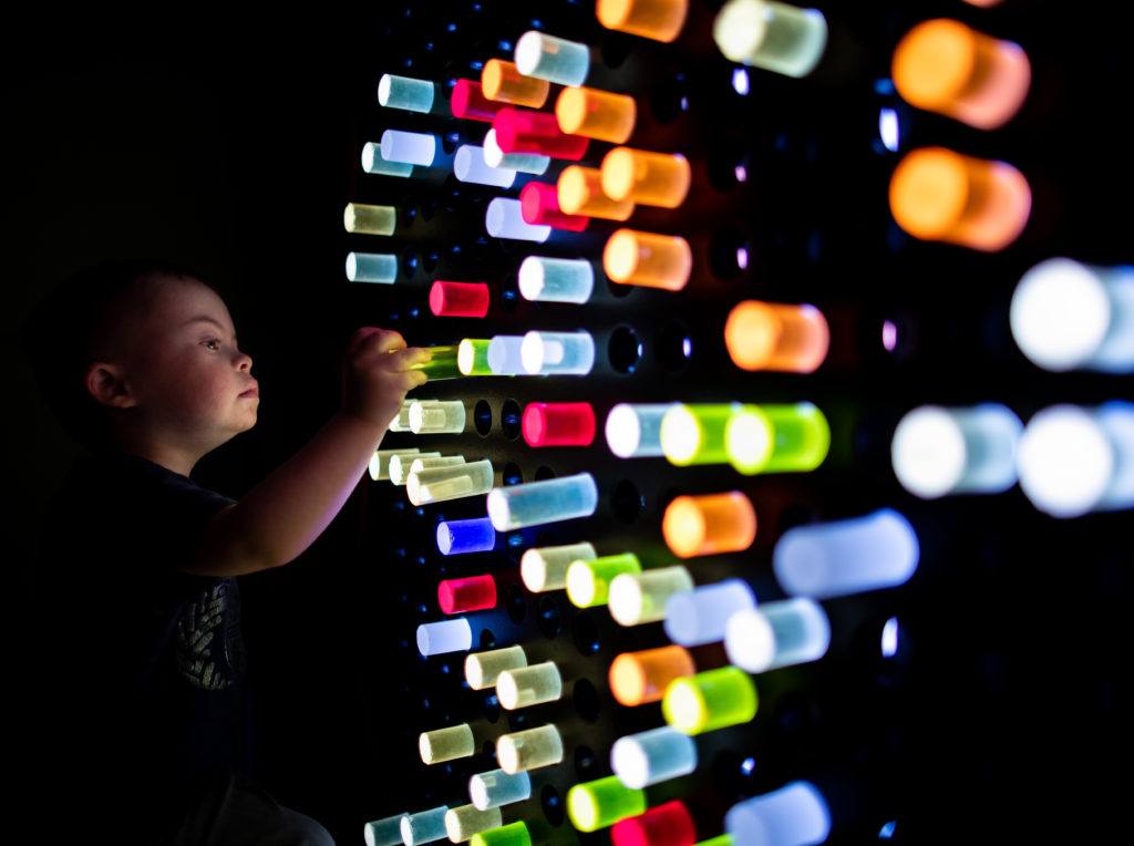 niño jugando con la pared iluminada