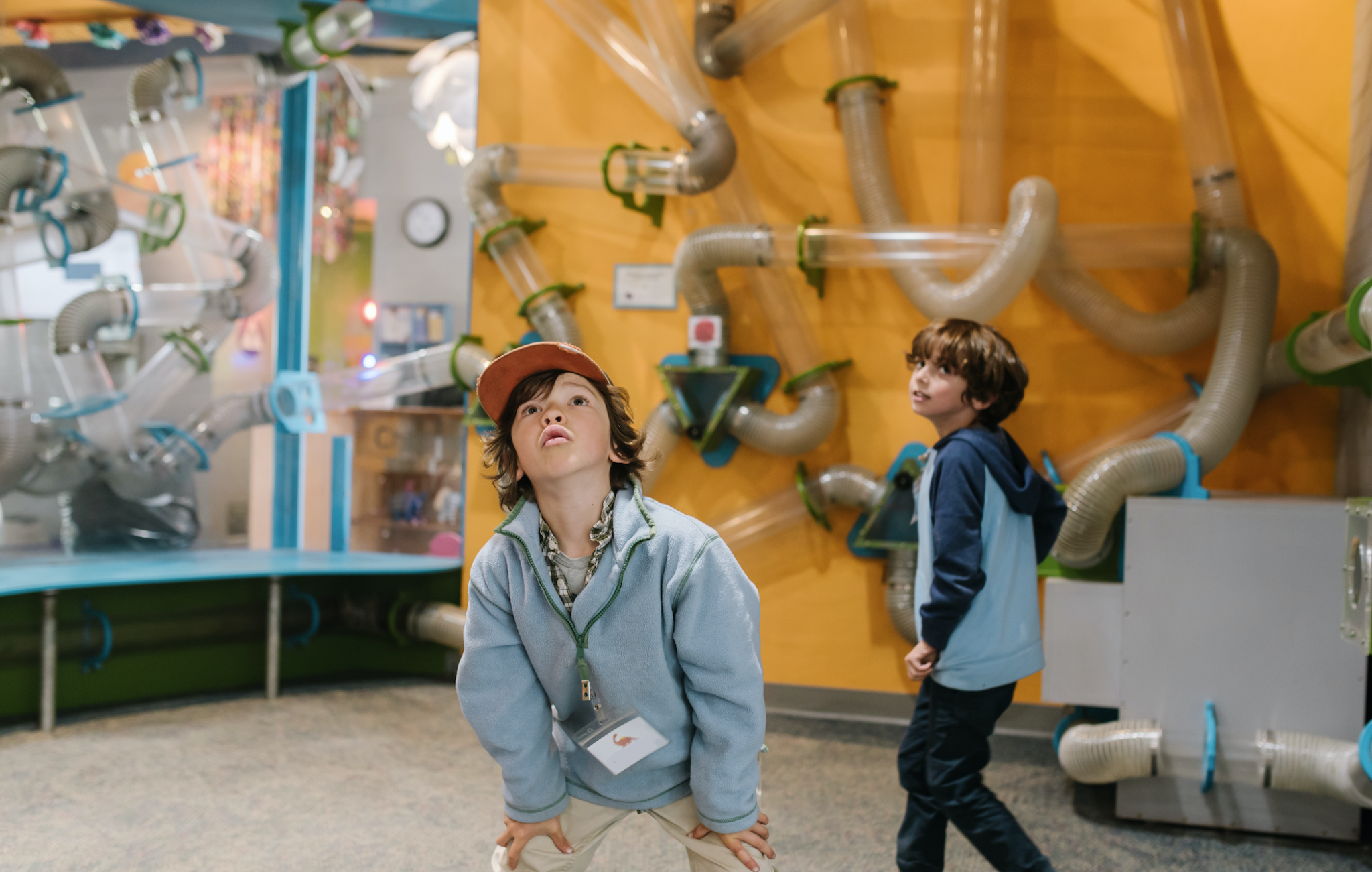 children stare in wonder at a floor to ceiling air maze that teaches about air currents
