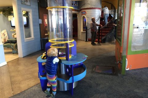 child playing with wind vortex tube