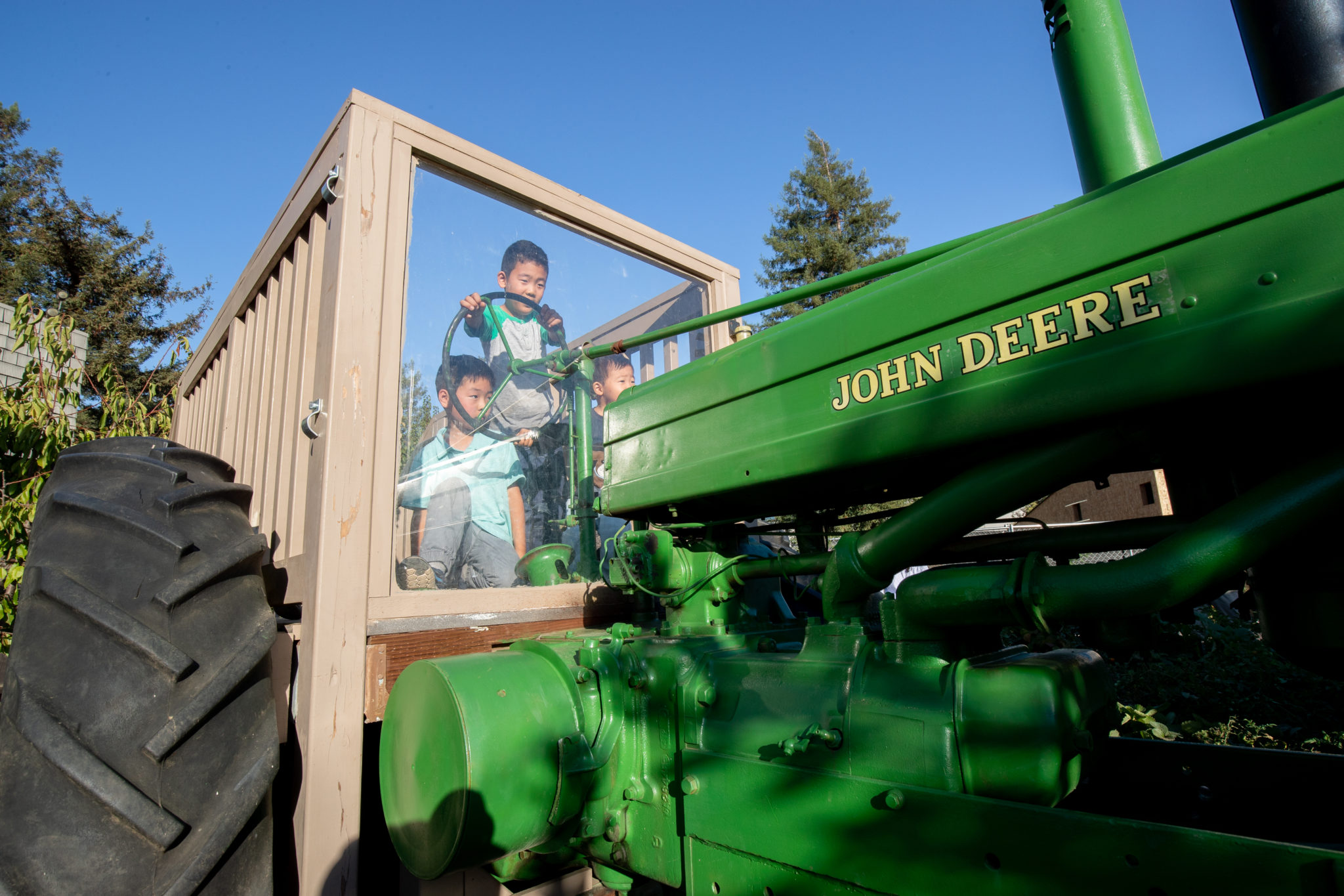 two children safely playing and experiencing hands-on a real tractor