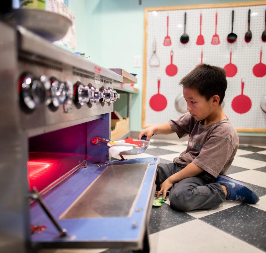 children playing with pretend oven