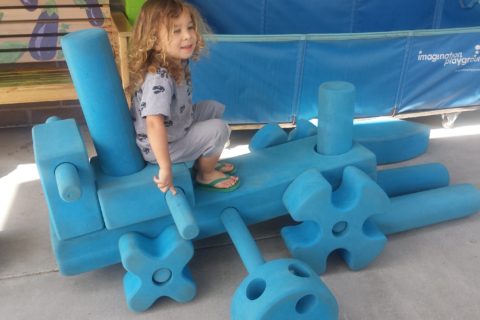 child playing in blue blocks area