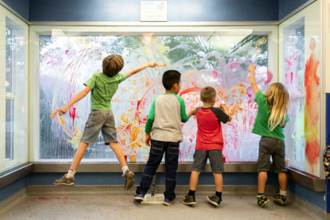 several kids playing at paint window