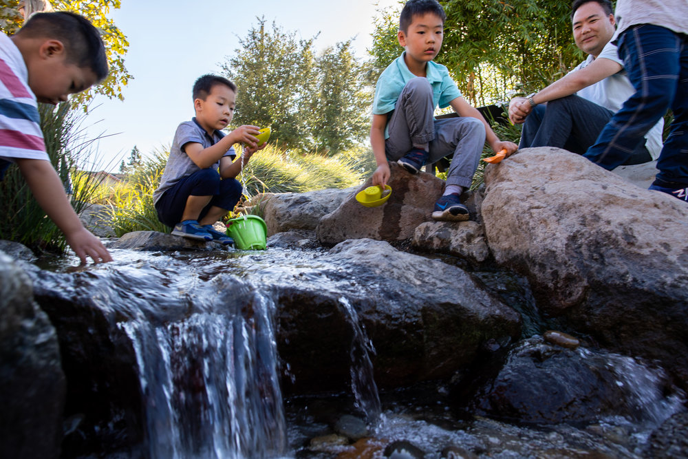 children playing on rocks in creek play area