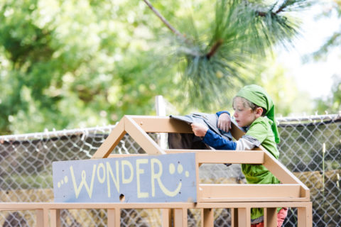 wonder camp sign and child on building