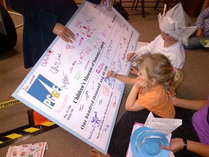 large check being drawn on by children