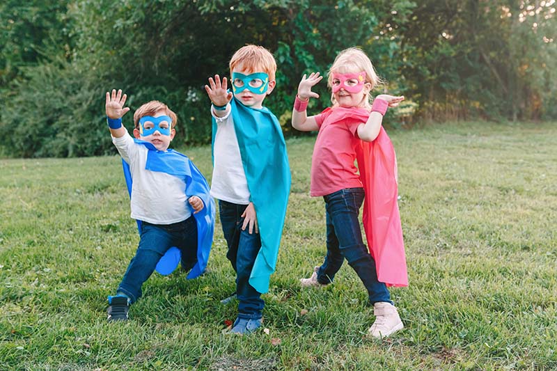 los niños se disfrazan con capas y máscaras de superhéroes hechas en casa