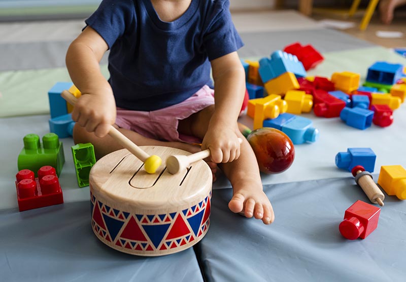 toddler playing with a drum and having fun