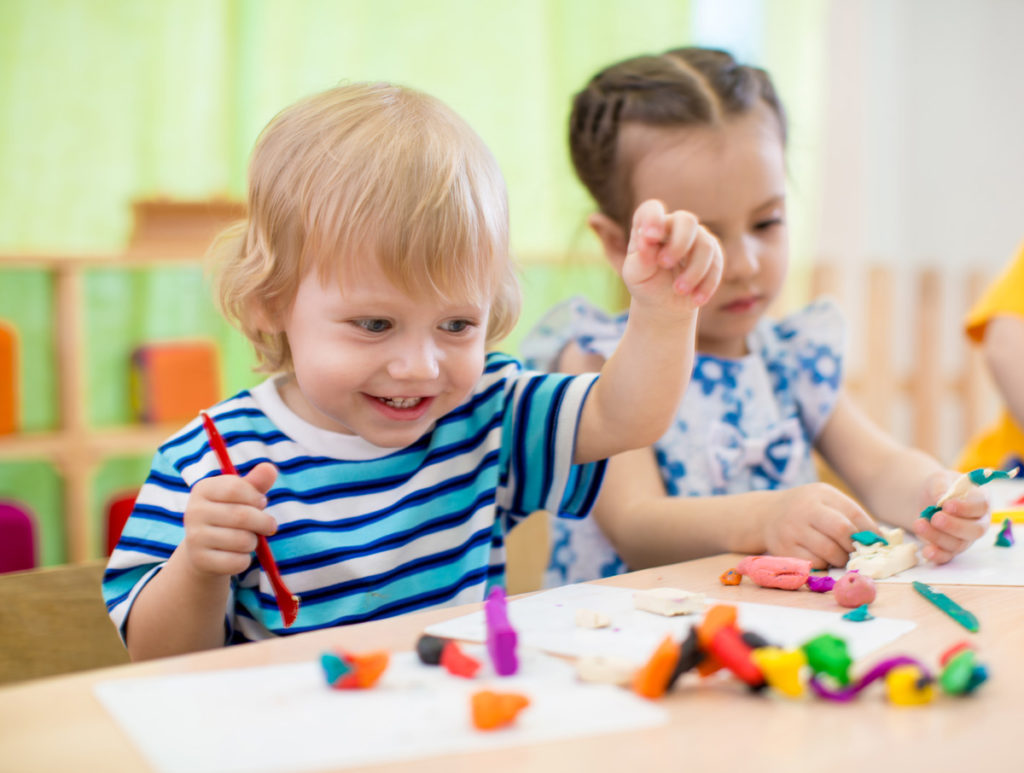 dos niños pequeños jugando con plastilina casera