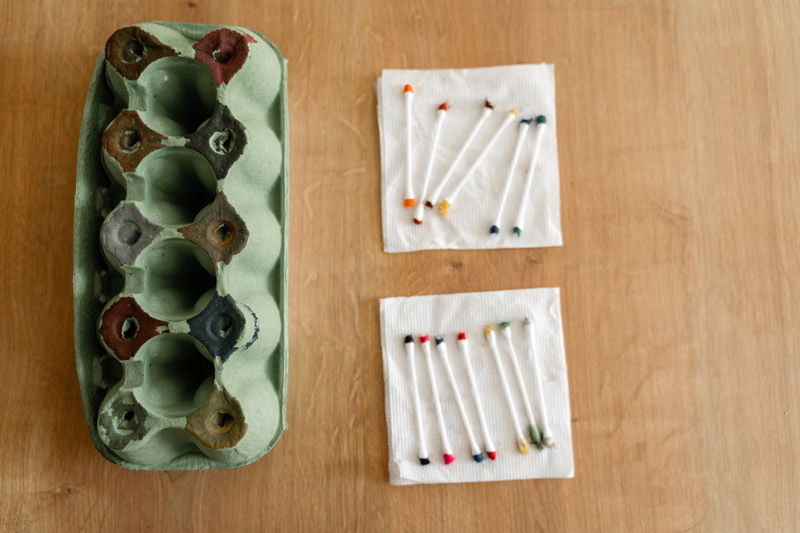 egg carton beside cotton swabs set up for toddler activity