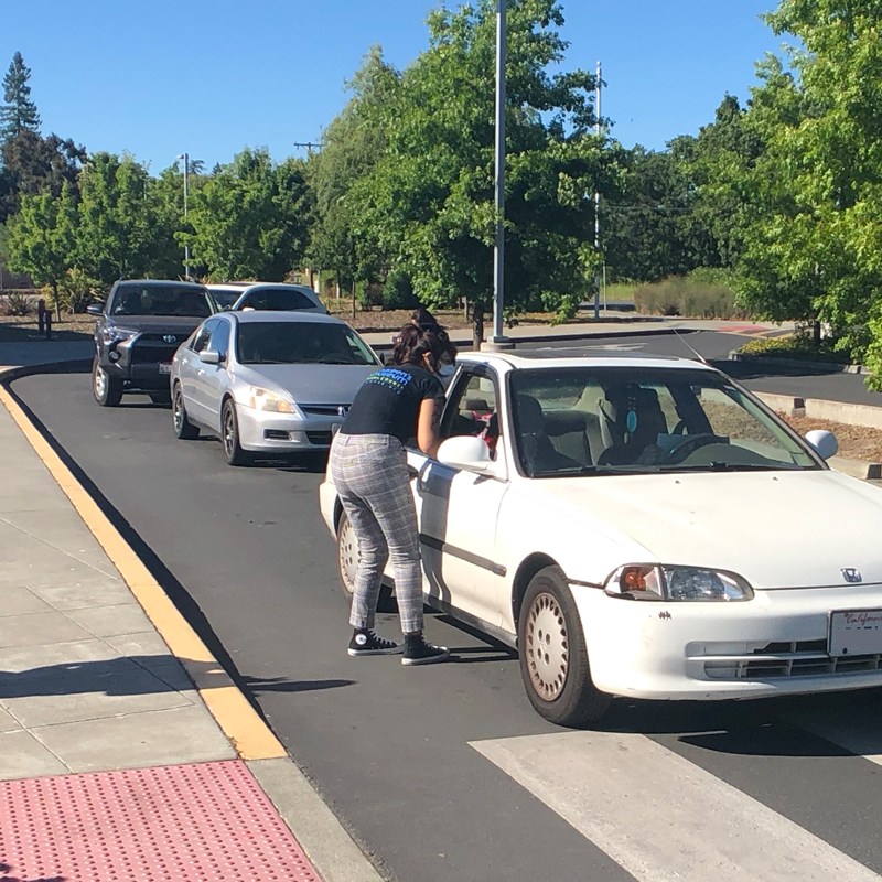 handing meals out to line of cars at community outreach project