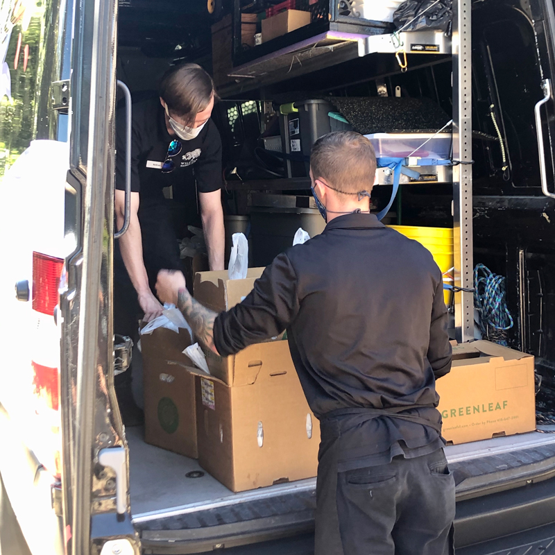 dos adultos cargando cajas en una furgoneta