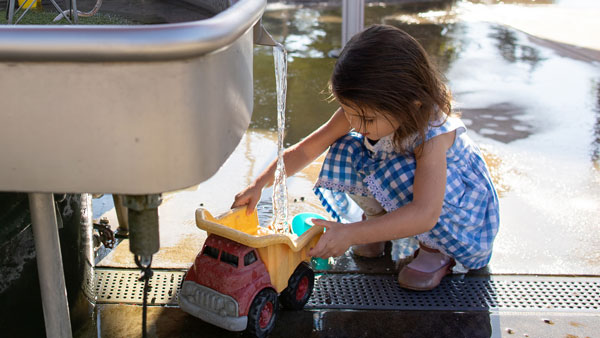 niña jugando con el chorro de agua en el museo infantil