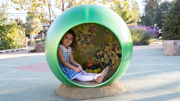 Niña en el Museo de los Niños del Condado de Sonoma dentro de una exposición de arte interactiva sobre el ciclo de vida de una mariposa