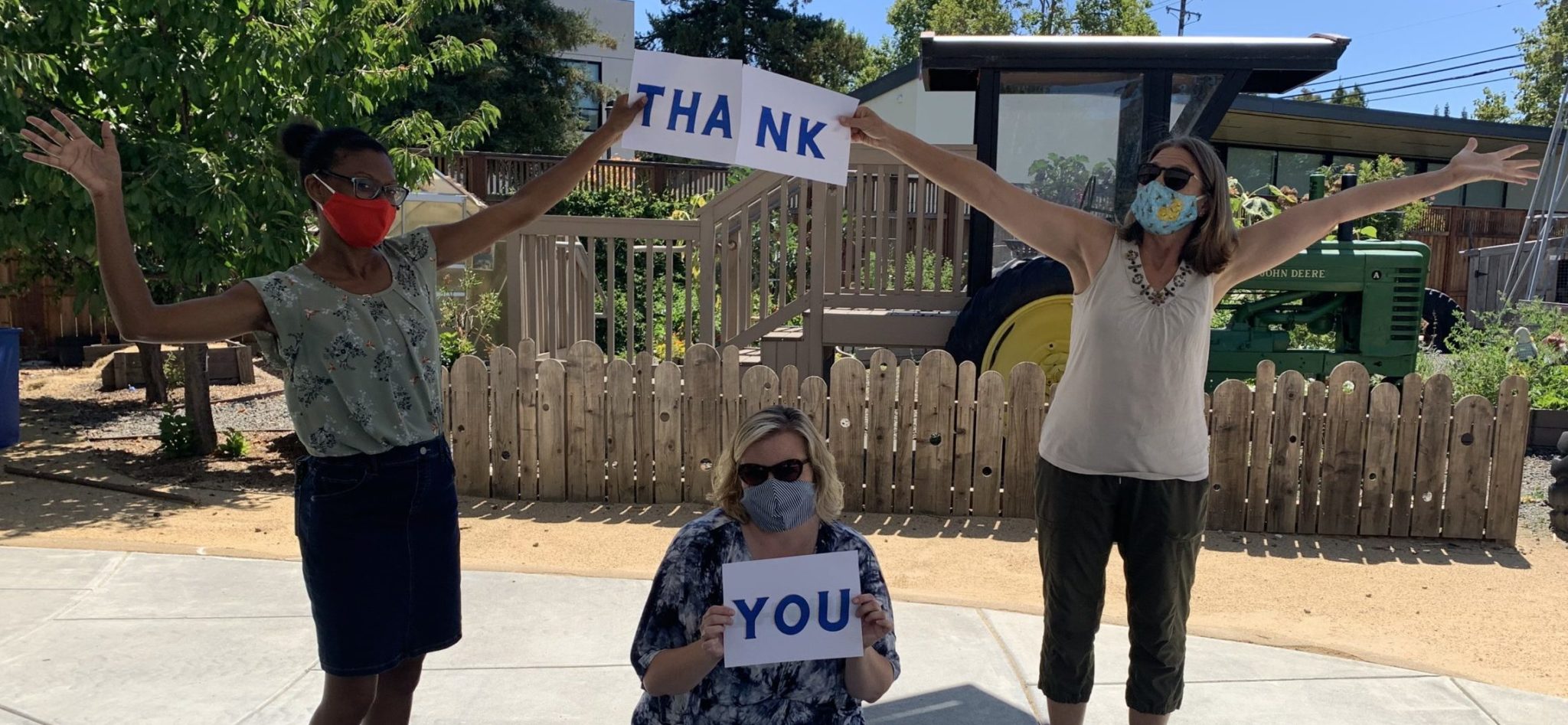 three adults holding up thank you signs