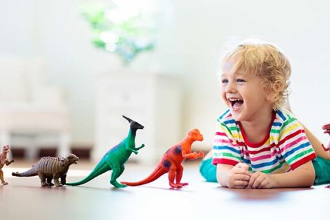 niño muy feliz jugando con juguetes de colores