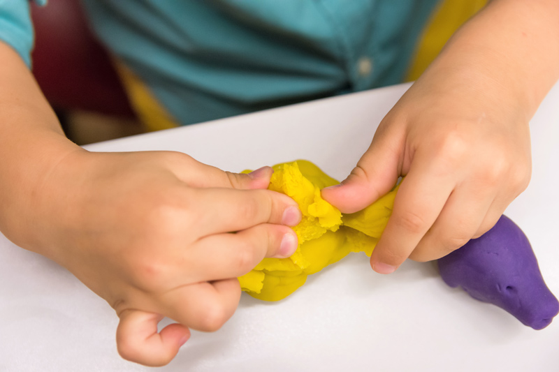 childs hands playing with homemade playdough