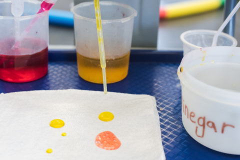 pipette dripping colored water onto cloth in kids experiment