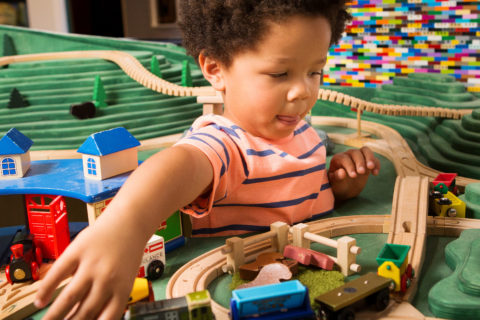 child playing with wooden toy train