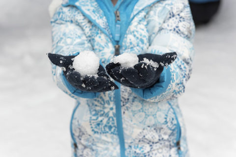 Child's hands wearing mittens and holding snow at CMOSC annual Snow Days Event in 2019