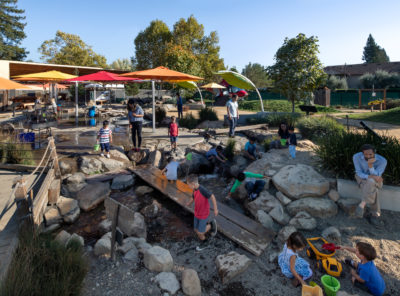 children playing at the Children's Museum of Sonoma County outdoors in the Russian River Waterway interactive exhibit.