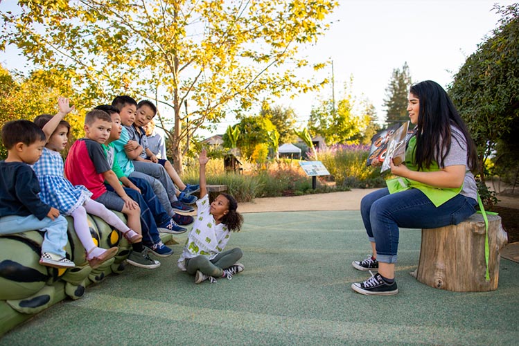 niños disfrutando de la hora del cuento en el Museo de los Niños del Condado de Sonoma sentados en la oruga de los cuentos