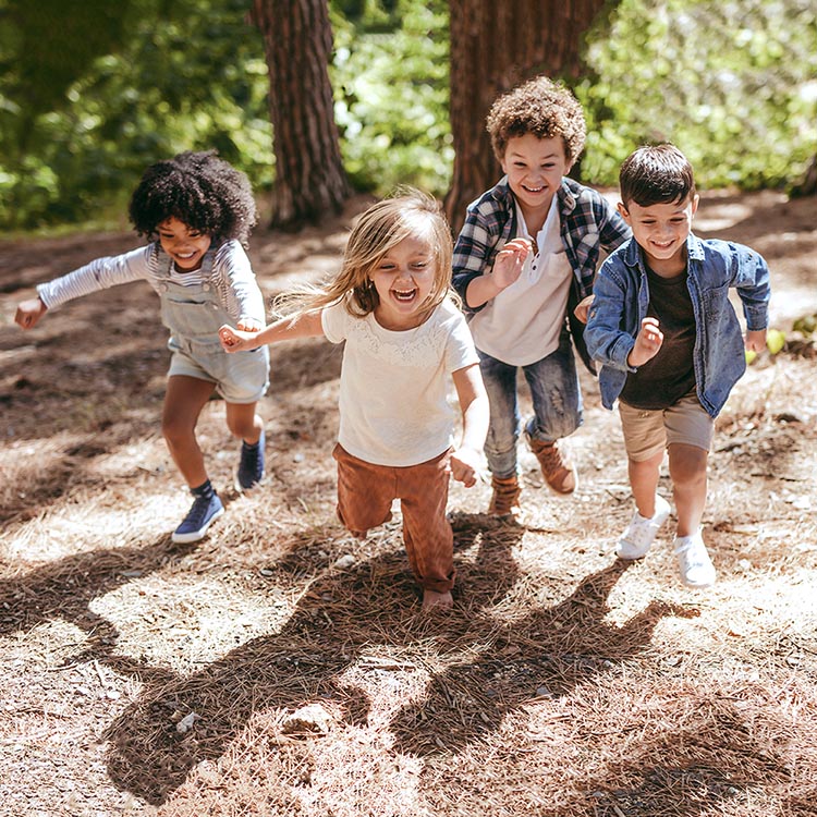 Kids running around playing in the forest