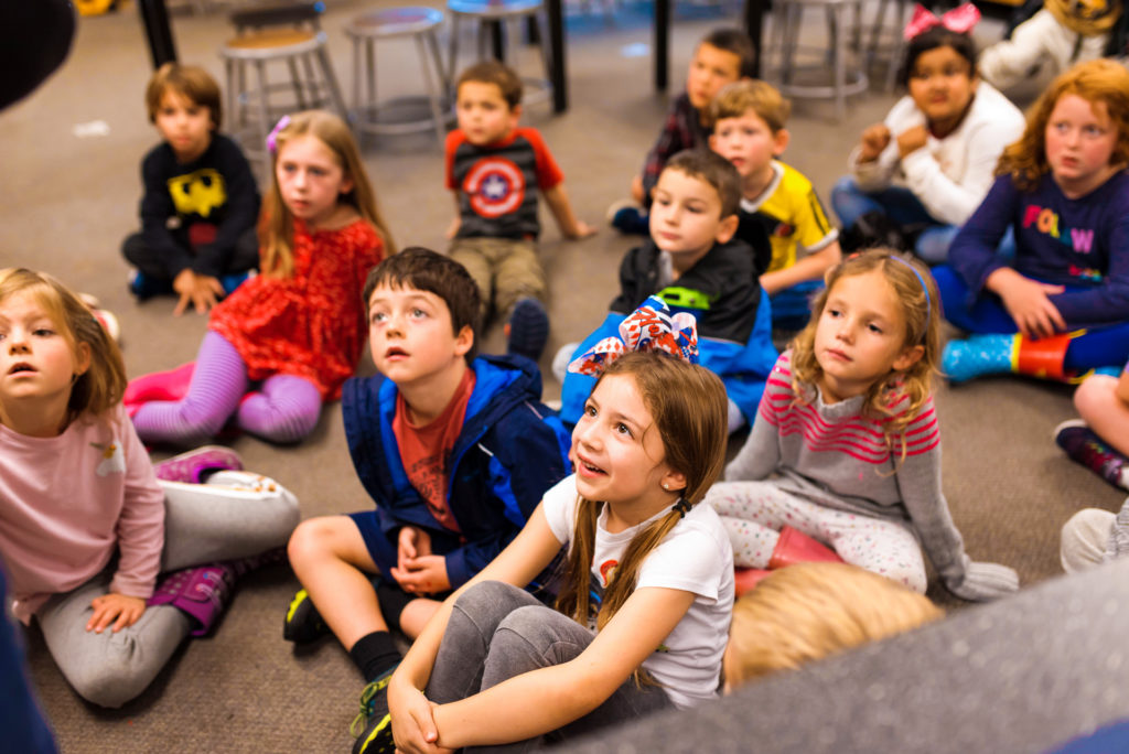 Los niños escuchan a un voluntario del Museo de los Niños del Condado de Sonoma que visita su comunidad
