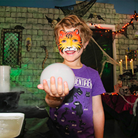 niño con disfraz de halloween haciendo una actividad de vapor de halloween: experimento científico con burbujas de hielo seco
