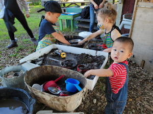 Niños jugando con el barro durante el programa Mud Lab en el Museo de los Niños del Condado de Sonoma