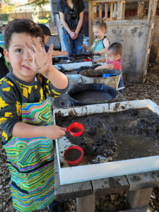 A child playing with mud during the Mud Lab program at the Children's Museum of Sonoma County