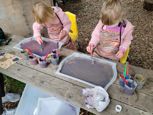 Niños pintando con barro durante el programa Mud Lab en el Museo de los Niños del Condado de Sonoma