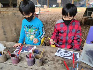 Children painting with mud during the Mud Lab program at the Children's Museum of Sonoma County