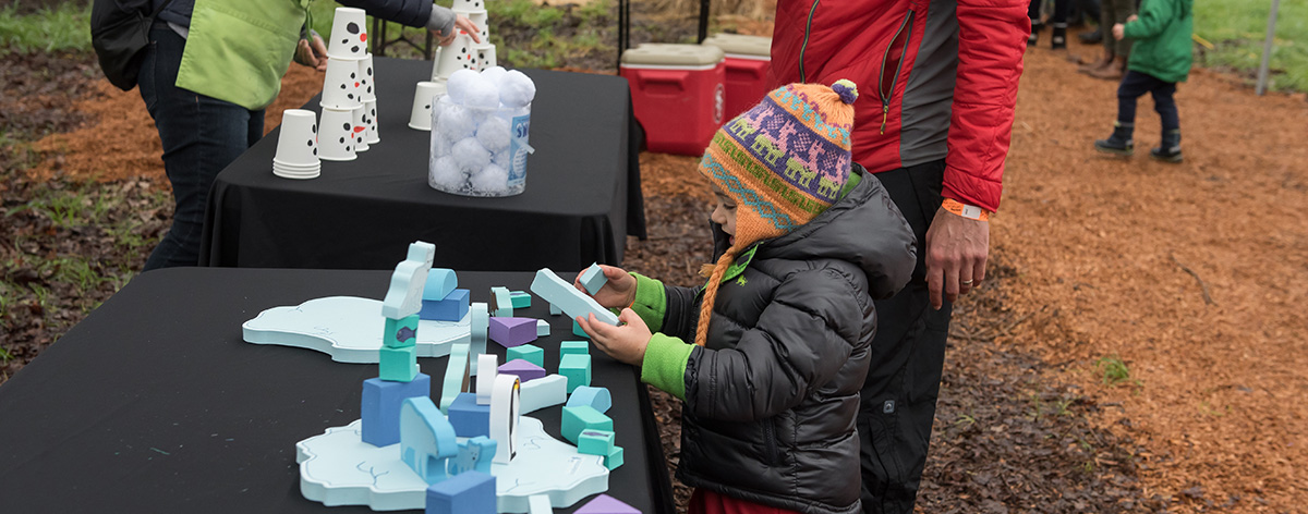 child playing a winter themed carnival style game at the children's museum of sonoma county