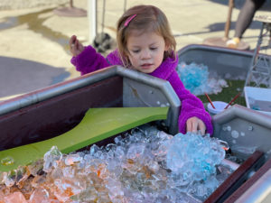 A child playing with an interactive ice sculpture at the children's museum of sonoma county
