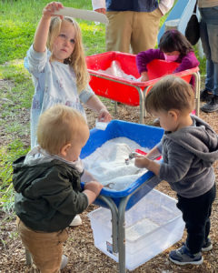 Three children playing with sensory bins at the children's museum of sonoma county