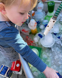 child playing with an interactive ice sculpture at the children's museum of sonoma county