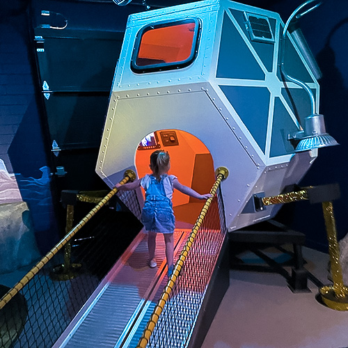 A child walking into a replica of a lunar lander in the Space Odyssey exhibit at the Children's Museum of Sonoma County