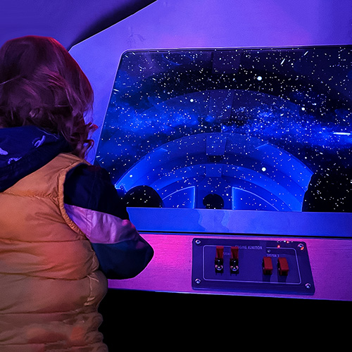 Un niño juega a pilotar una réplica de una nave espacial en la exposición Odisea del Espacio del Museo de los Niños del Condado de Sonoma