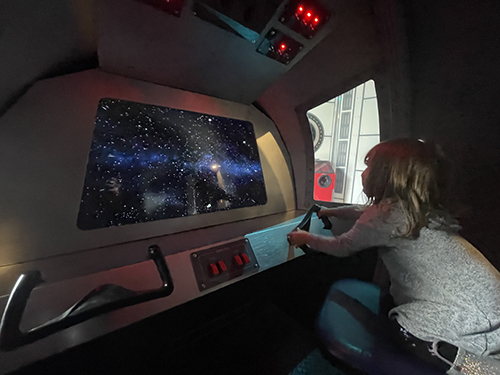 A child playing in an interactive space shuttle in the the Space Odyssey exhibit at the Children's Museum of Sonoma County