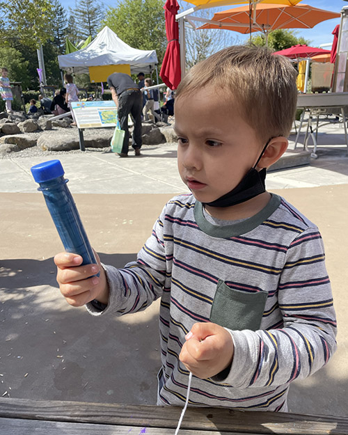 A children making a Glittery Galaxy Bottle at the Children's Museum of Sonoma County