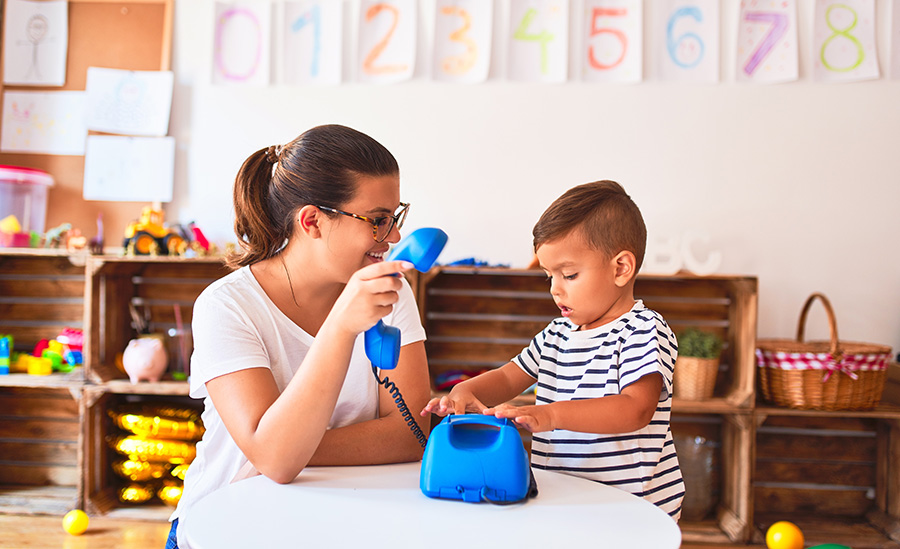 Adult and toddler playing with a blue toy/fake phone