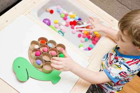 A toddler happily playing with STEAM learning activity