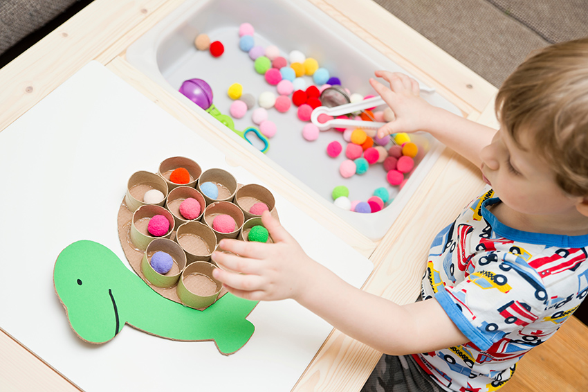 A toddler happily playing with  STEAM learning activity 