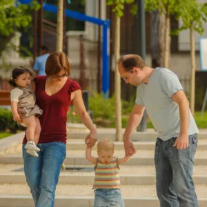 parents with 2 young children go for a walk at the park