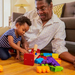 grandfather plays with his grandchild with children's building blocks