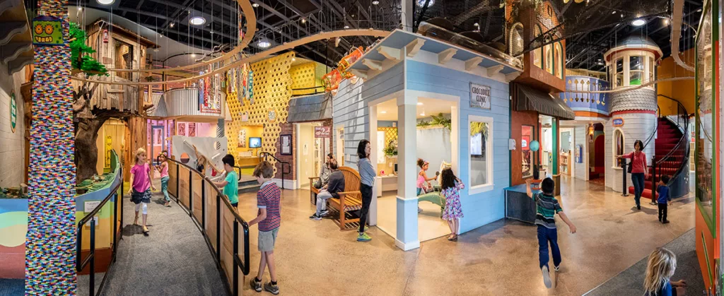 Una vista panorámica del interior del Museo Infantil del Condado de Sonoma en la que niños y padres juegan con exposiciones interactivas.