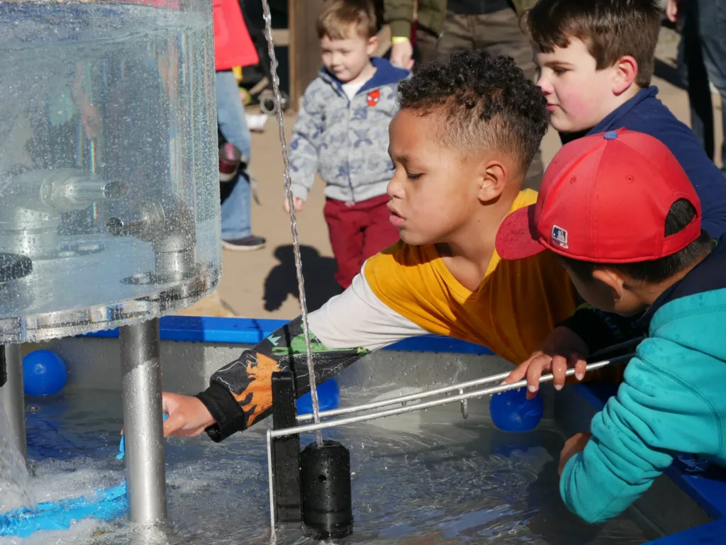 children playing with outdoor water exhibit at the Children's Museum